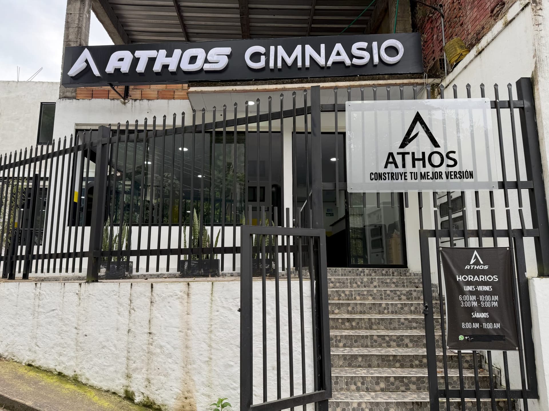 Entrada de ATHOS Gimnasio con el letrero y el lema Construye tu mejor versión